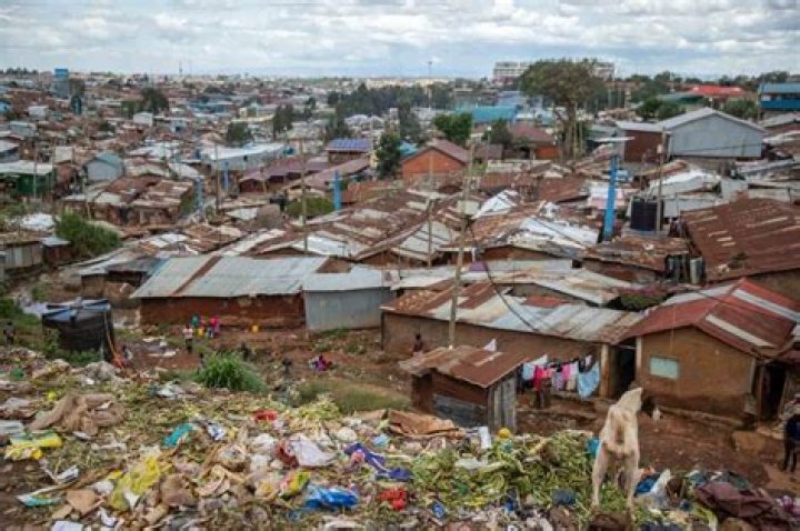 How are slums being improved?