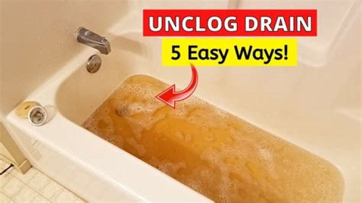 How do you unclog a tub with standing water?